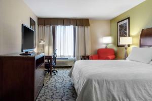 a hotel room with a bed and a flat screen tv at Hilton Garden Inn Portland Airport in Portland +40 photos