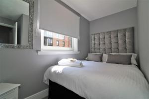 a bedroom with a large white bed with a mirror at 2 Bedroom Apartment at SECC Hydro FREE PARKING in Glasgow