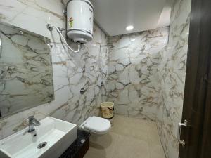 a bathroom with a sink and a toilet and a mirror at Hotel Seeta Since 1965 in Amritsar