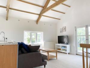 a living room with a couch and a tv at Swallows Drift in Newquay