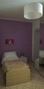 una camera con letto e parete viola di Mirage B&B ad Alezio