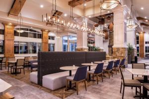 a restaurant with tables and chairs and chandeliers at Hilton Garden Inn Bend in Bend