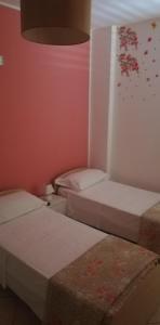 una camera con due letti e una parete rosa di Mirage B&B ad Alezio