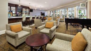 a lobby with chairs and a piano and a bar at DoubleTree by Hilton Raleigh Durham Airport at Research Triangle Park in Durham