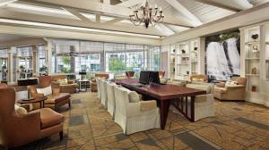 a lobby with a desk and chairs and a table and a room at DoubleTree by Hilton Raleigh Durham Airport at Research Triangle Park in Durham
