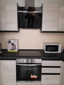 a kitchen with a stove and a microwave at CARPE DIEM in Oristano