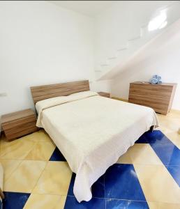 - une chambre avec un lit et un sol en damier dans l'établissement DA DANY e ELIA, à Irgoli