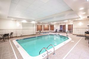 a pool in a hotel room with tables and chairs at Hilton Garden Inn Richmond Airport in Sandston