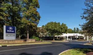 a building with a sign in front of a road at Hilton Durham near Duke University in Durham