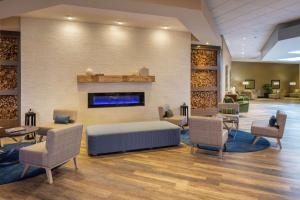a lobby with a bed and chairs and a fireplace at Hilton Durham near Duke University in Durham