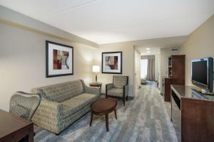 a living room with a couch and a tv at Hilton Garden Inn Richmond Airport in Sandston