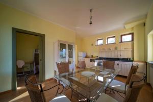 a dining room with a glass table and chairs at Castelvecchio in Sarnano