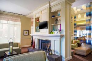 a living room with a fireplace and a tv at Hilton Garden Inn Richmond Innsbrook in Short Pump