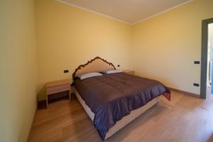 una camera con letto e pavimento in legno di Castelvecchio a Sarnano
