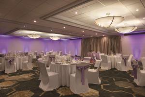 a banquet room with white tables and chairs and a purple wall at Embassy Suites by Hilton Richmond in Richmond +49 photos