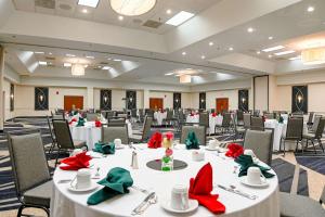 a banquet hall with white tables with red and green bows at DoubleTree by Hilton Richmond - Midlothian in Midlothian