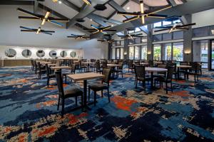een eetkamer met tafels, stoelen en ramen bij DoubleTree by Hilton Bakersfield in Bakersfield
