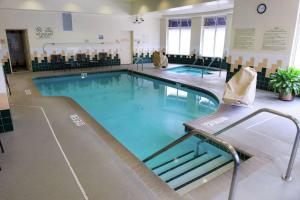 a large swimming pool with blue water in a building at Hilton Garden Inn Rochester Downtown in Rochester