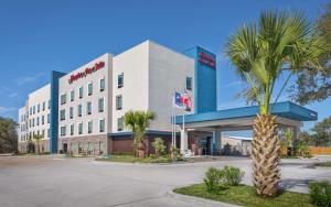 a building with a palm tree in front of it at Hampton Inn & Suites Rockport-Fulton in Rockport