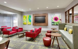 a waiting room with red chairs and a flat screen tv at Hampton Inn & Suites Rockport-Fulton in Rockport