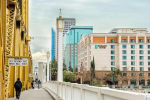 uma ponte numa cidade com pessoas a caminhar sobre ela em Embassy Suites by Hilton Sacramento Riverfront Promenade em Sacramento