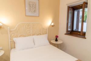 una camera con un letto bianco e una finestra di Bardis Hidden Gem a Volos