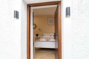une porte menant à une chambre avec un lit dans l'établissement Bardis Hidden Gem, à Vólos