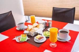 stół ze śniadaniem obejmującym chleb, kawę i sok pomarańczowy w obiekcie GOLD INFINITY w mieście Tacna