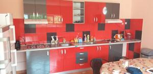 una cucina con armadi rossi e parete rossa di Vila Roxana 2 Mai a 2 Mai