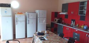 una cucina con 2 frigoriferi bianchi e un tavolo di Vila Roxana 2 Mai a 2 Mai Altre 9 foto