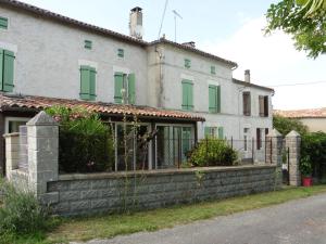 una antigua casa blanca con una pared de piedra. en Gîte 4 pers avec option sauna- Classé 3 étoiles- Sud charente, en Lagarde-sur-le-Né