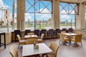 a restaurant with tables and chairs and a large window at Embassy Suites by Hilton San Diego Bay Downtown in San Diego