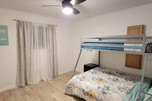 1 Schlafzimmer mit 2 Etagenbetten und einem Fenster in der Unterkunft Casa Sunrise, Large Home, Minutes from Airport, YRMC, Mexico Borders in Yuma