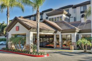 a hotel with a palm tree in front of it at Hilton Garden Inn San Diego Del Mar in San Diego