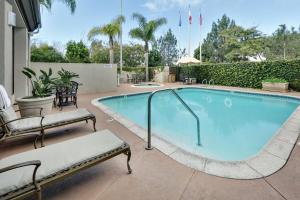 una gran piscina con 2 sillas alrededor en Hilton Garden Inn San Diego Del Mar en San Diego
