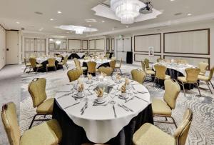 una sala de conferencias con mesas, sillas y una lámpara de araña en Hilton Garden Inn San Diego Del Mar en San Diego