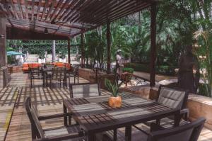 un patio con mesa, sillas y árboles en Hilton Princess San Pedro Sula en San Pedro Sula