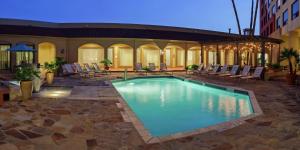 una piscina con sillas y un edificio en DoubleTree by Hilton San Antonio Downtown en San Antonio