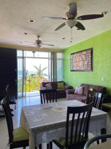 a living room with a table and a ceiling fan at CONDOMINIO PALMEIRAS in Acapulco
