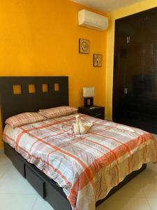 un dormitorio con una cama con un animal de peluche en CONDOMINIO PALMEIRAS en Acapulco