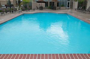 a large blue swimming pool with tables and chairs at Hilton Garden Inn New Braunfels in New Braunfels