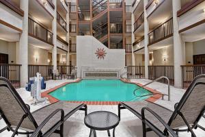 聖安東尼奧的住宿－聖安東尼奧機場希爾頓花園酒店，一座带椅子的建筑中央游泳池
