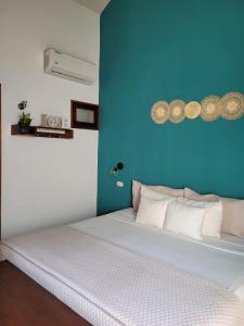 1 dormitorio con cama blanca y pared azul en Hotel con Corazón en Granada