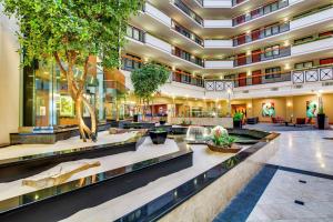 an office building with a large lobby with trees at Embassy Suites by Hilton Louisville East in Louisville