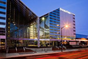 a large glass building on a city street at night at DoubleTree by Hilton Hotel South Bend in South Bend