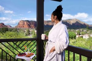 a woman standing on a balcony with a cup of coffee at Hilton Sedona Resort at Bell Rock in Sedona