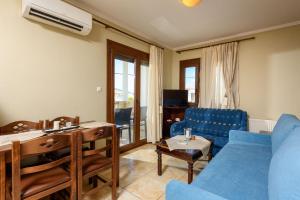a living room with a blue couch and a table at Villa Angel in Limenas