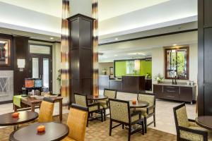 a lobby with tables and chairs and a kitchen at Hilton Garden Inn Seattle/Bothell in Bothell