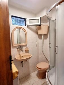 y baño con aseo, lavabo y ducha. en Cozy House Haj Nehaj en Sutomore