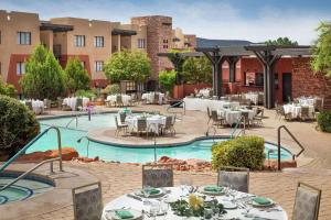 an outdoor dining area with tables and chairs and a pool at Hilton Sedona Resort at Bell Rock in Sedona